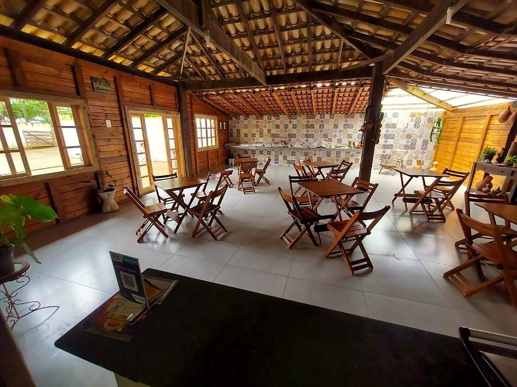 Salão do café da manhã, com paredes de madeira, mesas e azulejos